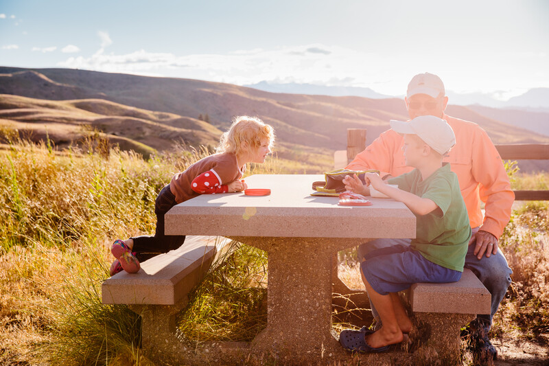 A man and two young children sit at a picnic table in Wenatchee, Washington.